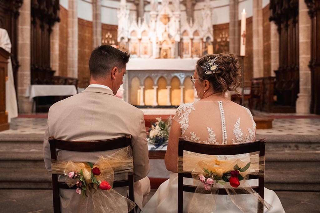 Les mariés de dos face à l'autel de l'église